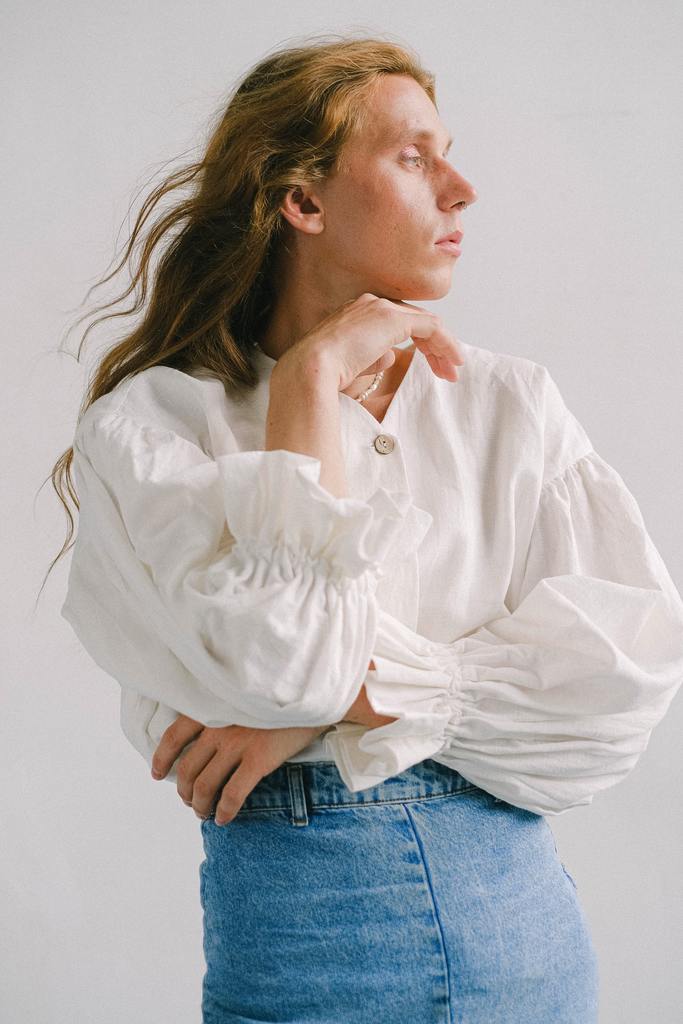 Model wearing a blouse and denim mini skirt reminiscent of non binary fashion